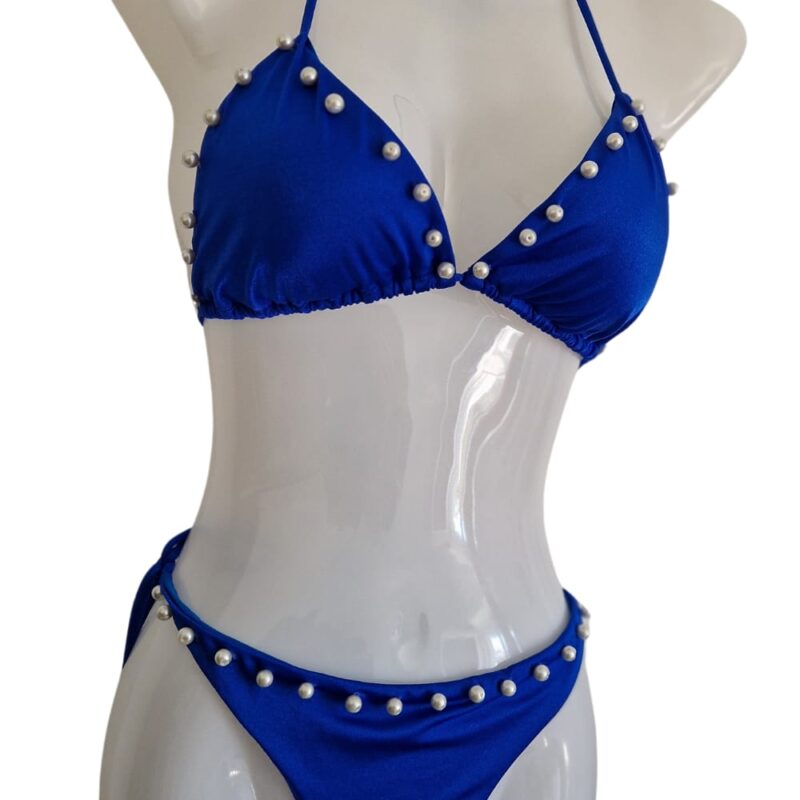 Blauer Bikini mit weissen Perlen verziert für eine perfekte Bräune.